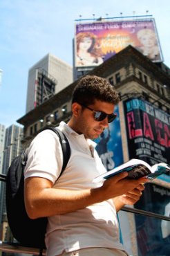 Photo of a traveler reading a Lonely Plant guide book in New York City